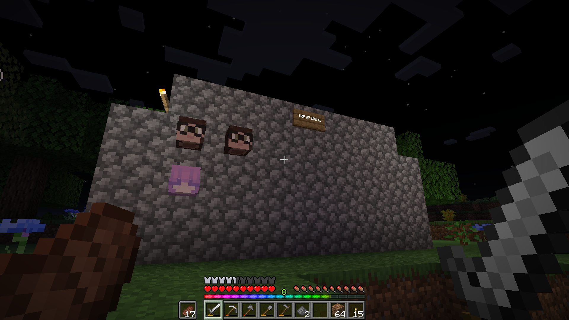 An einer Bruchsteinmauer, die durch ein Schild mit „Wall of Shame“ beschriftet ist, hängen zwei von meinen Köpfen und einer von Alice.